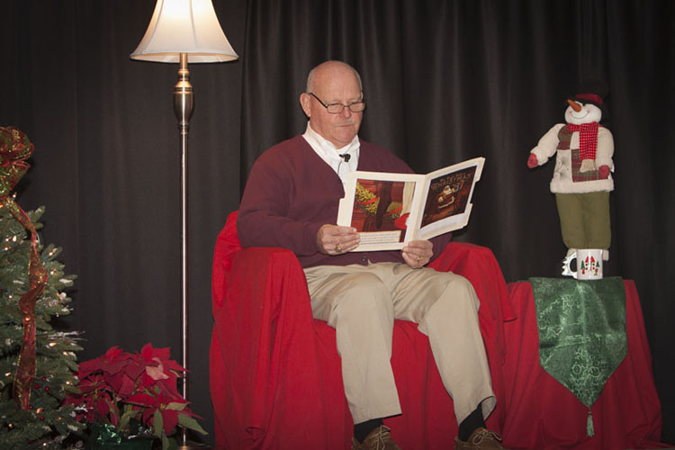 A reader sharing a holiday story during the Christmas concert